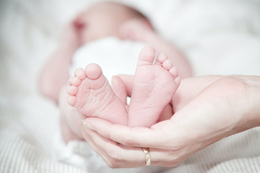 A mother holding baby’s feet