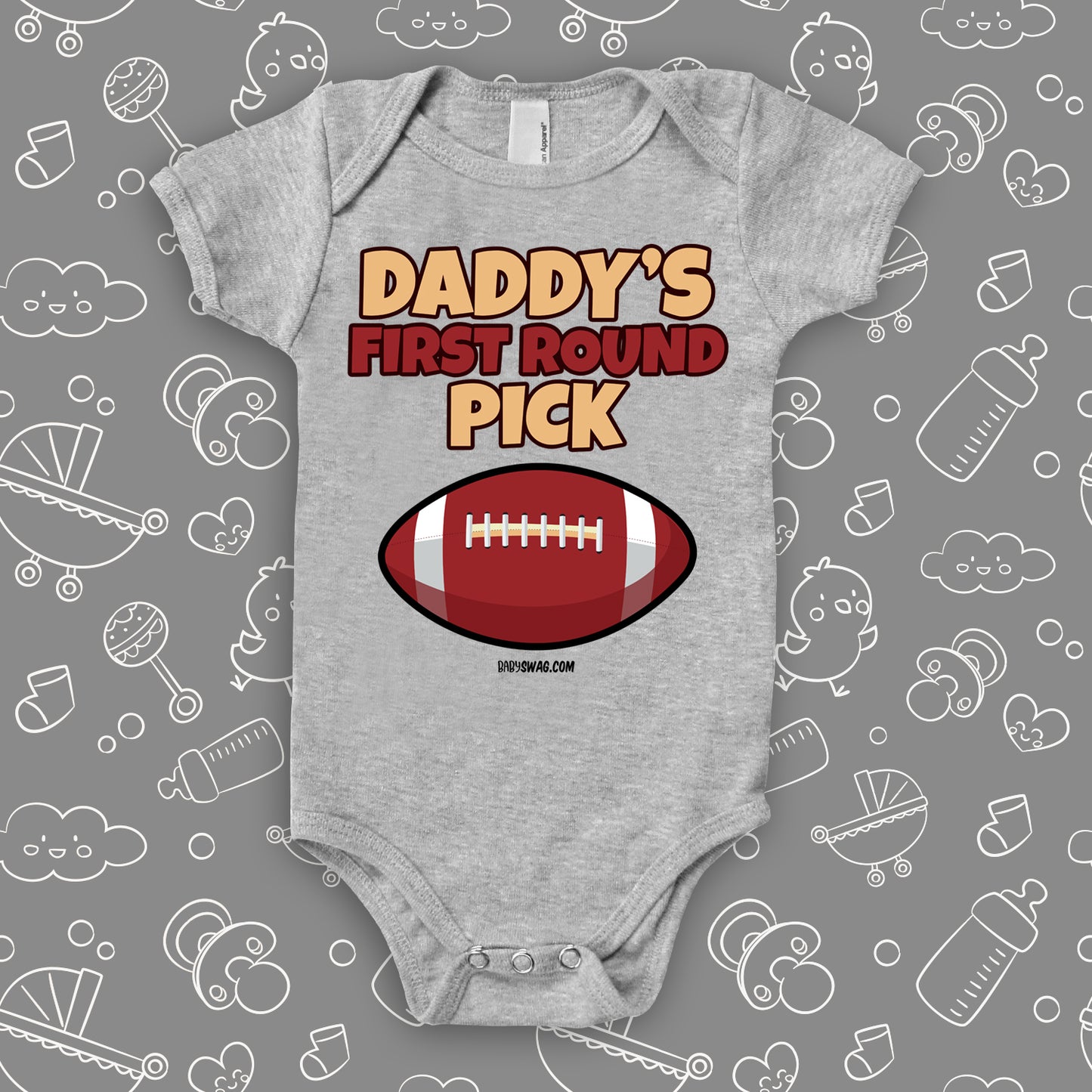 Cool baby onesie saying "Daddy's first round pick" and including the image of a football, color grey.