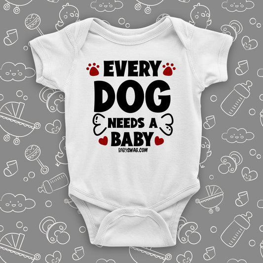 White cute baby onesie saying "Every dog needs a baby", red paws and bone also printed.