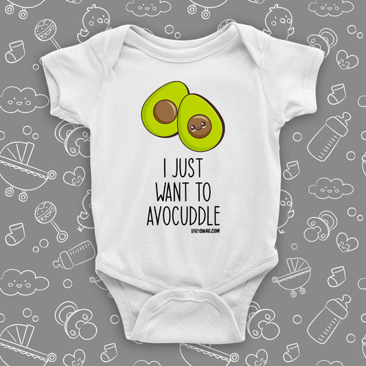 White cute baby onesie with an image of two halves of avocado and saying: "I just want to avocuddle".