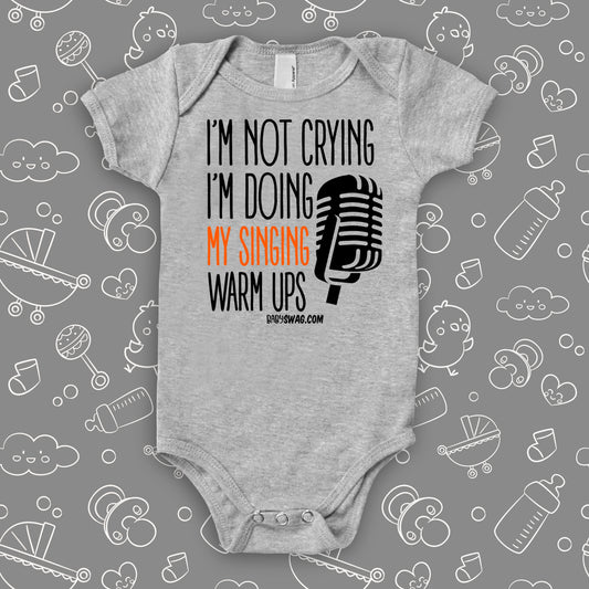 Hilarious baby onesies with saying "I'm Not Crying, I'm Doing My Singing Warm Ups" in grey.