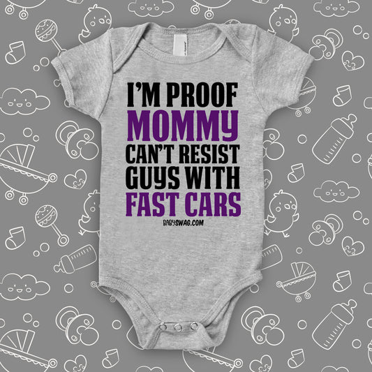 A grey hilarious baby onesie sayng "I'm Proof Mommy Can't Resist Guys With Fast Cars"