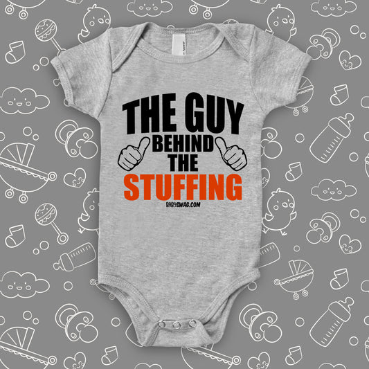 Funny baby onesies with saying "The Guy Behind The Stuffing" in grey.