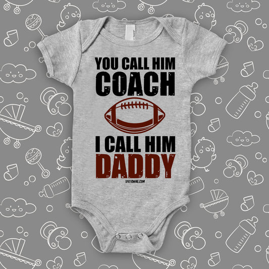 Cute baby onesie with saying "You Call Him Coach, I Call Him Daddy" in grey.