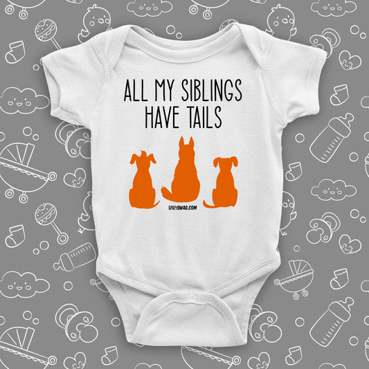 White cute baby onesie with "All My Siblings Have Tails"  saying and an image of three dogs. 