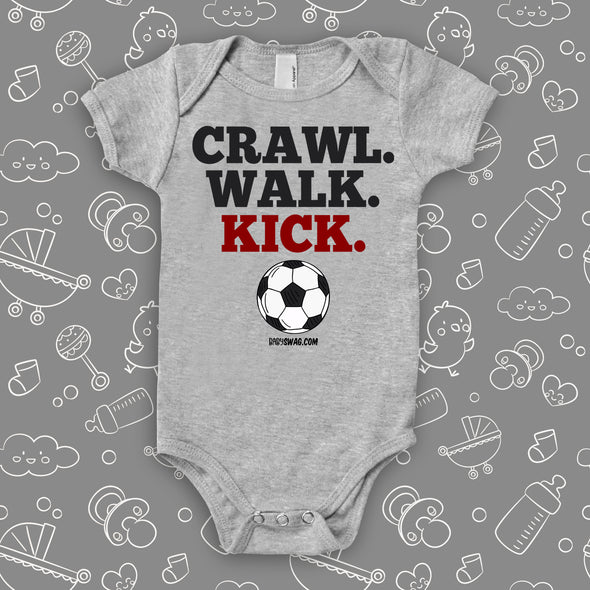 baby boy onesies with the caption "Crawl. Walk. Kick" in grey. 