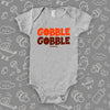 Funny baby onesies with saying "Gobble, gobble" in grey. 
