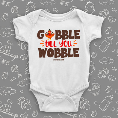 Funny baby onesies with saying "Gobble Till You Wobble" in white.