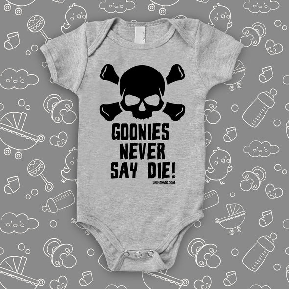 Grey cool baby onesie with an image of a skull and a "Goonies Never Say Die" print.