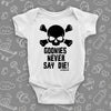 White cool baby onesie with an image of a skull and a "Goonies Never Say Die" print.