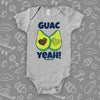 Grey unique baby onesie with "Guac Yeah!" print and image of avocade with heart-shaped stone. 