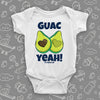  White unique baby onesie with "Guac Yeah!" print and image of avocade with heart-shaped stone. 