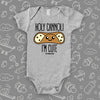 Grey cute baby onesie saying "Holi cannoli, I'm cute".