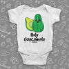 White hiarious baby onesie saying "Holy Guacamole" and an avocado image.