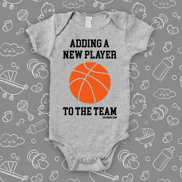 Unique baby onesies with saying "Adding A New Player To The Team" in white. 