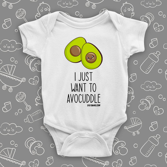 White cute baby onesie with an image of two halves of avocado and saying: "I just want to avocuddle". 