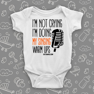 Hilarious baby onesies with saying "I'm Not Crying, I'm Doing My Singing Warm Ups" in white.
