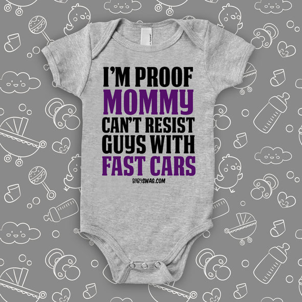 A grey hilarious baby onesie sayng "I'm Proof Mommy Can't Resist Guys With Fast Cars"   