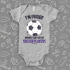 Funny baby onesies with "I'm Proof Mommy Can't Resist Soccer Players" in grey. 