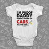 A white funny baby onesies saying "I'm Proof Daddy Doesn't Always Work On Cars All The Time"