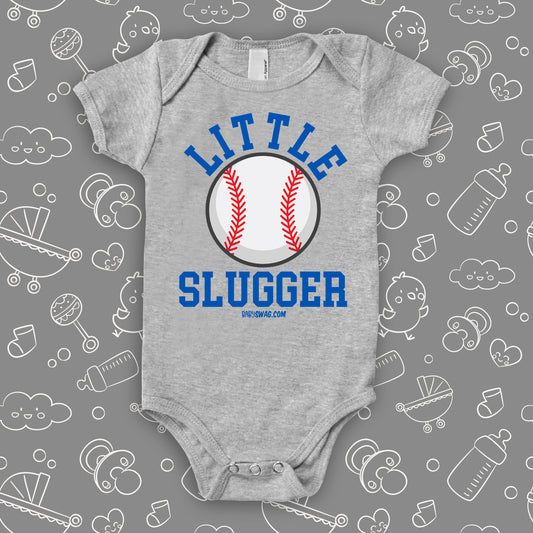 Graphic baby onesies with baseball print on it and saying "Little Slugger" in grey
