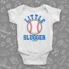 Graphic baby onesies with baseball print on it and saying "Little Slugger" in white.