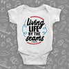 Cool baby onesies with saying "Living Life By The Seams" in white.