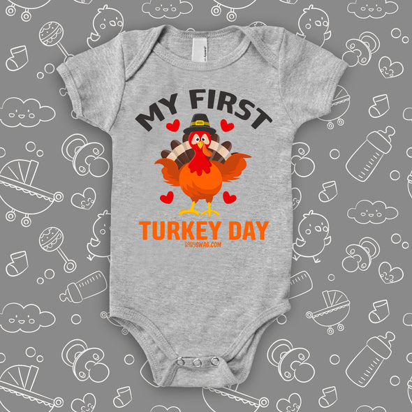 Cute baby onesies with saying "My First Turkey Day"  and an image of a turkey in grey. 
