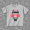 Toddler shirt with saying "My Mom Is Stronger Than Your Dad" in grey. 