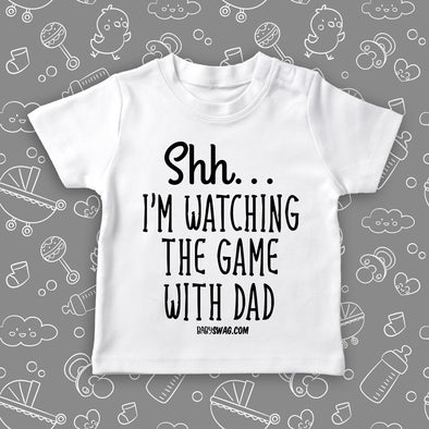Toddler boy shirt with saying: "Shh.. I'm Watching The Game With Dad" in white.