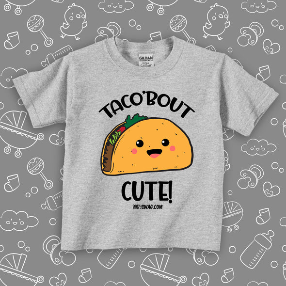 Funny toddler graphic tees with saying "Taco'bout Cute" in grey. 