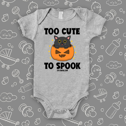 Grey cute baby onesie saying "Too Cute To Spook" with an image of a kitten coming out of the Halloween pumpkin