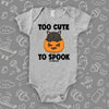 Grey cute baby onesie saying "Too Cute To Spook" with an image of a kitten coming out of the Halloween pumpkin  