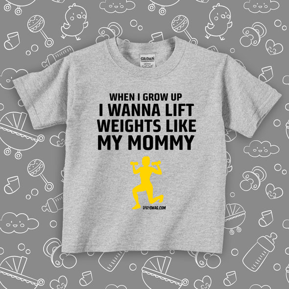 Funny toddler shirt with saying "When I Grow Up I Wanna Lift Weights LIke My Mommy" in grey.